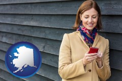 alaska map icon and middle-aged woman using a cell phone