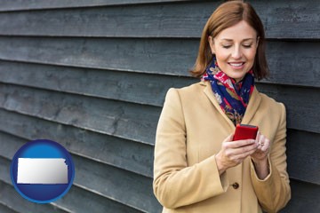 middle-aged woman using a cell phone - with Kansas icon